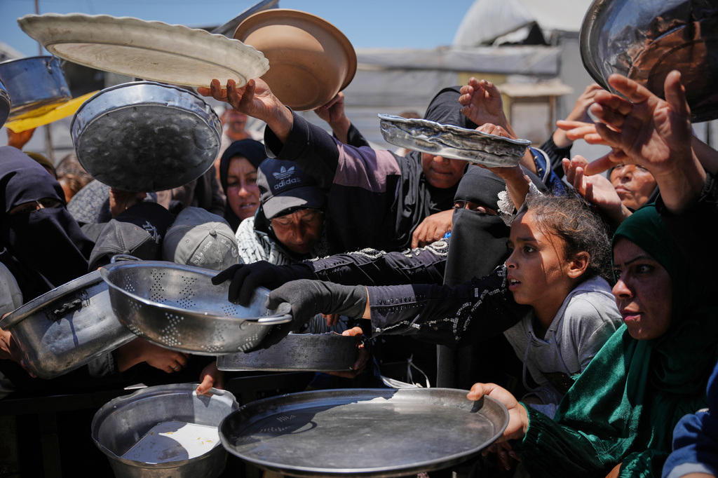 FILE -Palestinians wait to receive donated food at a distribution center in Khan Younis, Gaza Strip, May 27, 2026. (AP Photo/Abdel Kareem Hana, File)