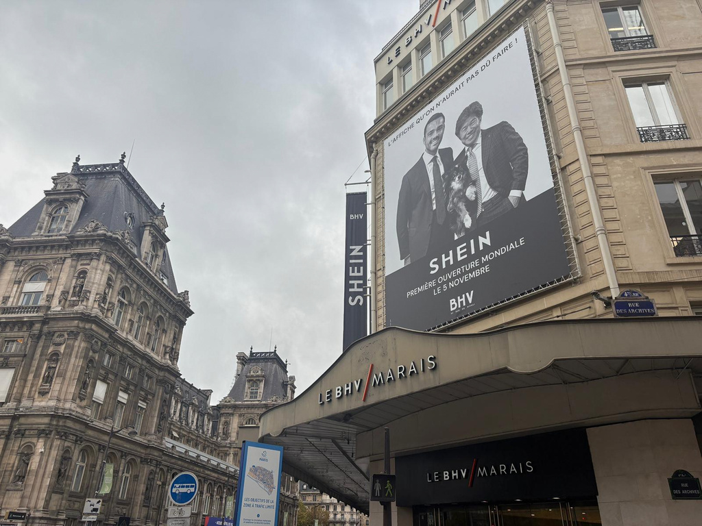 An advertising poster of Shein hangs outside the BHV Marais departement store in Paris, Monday, Oct. 3, 2025, where Shein is due to open its first permanent physical store world wide. (AP Photo/Nicolas Garriga)