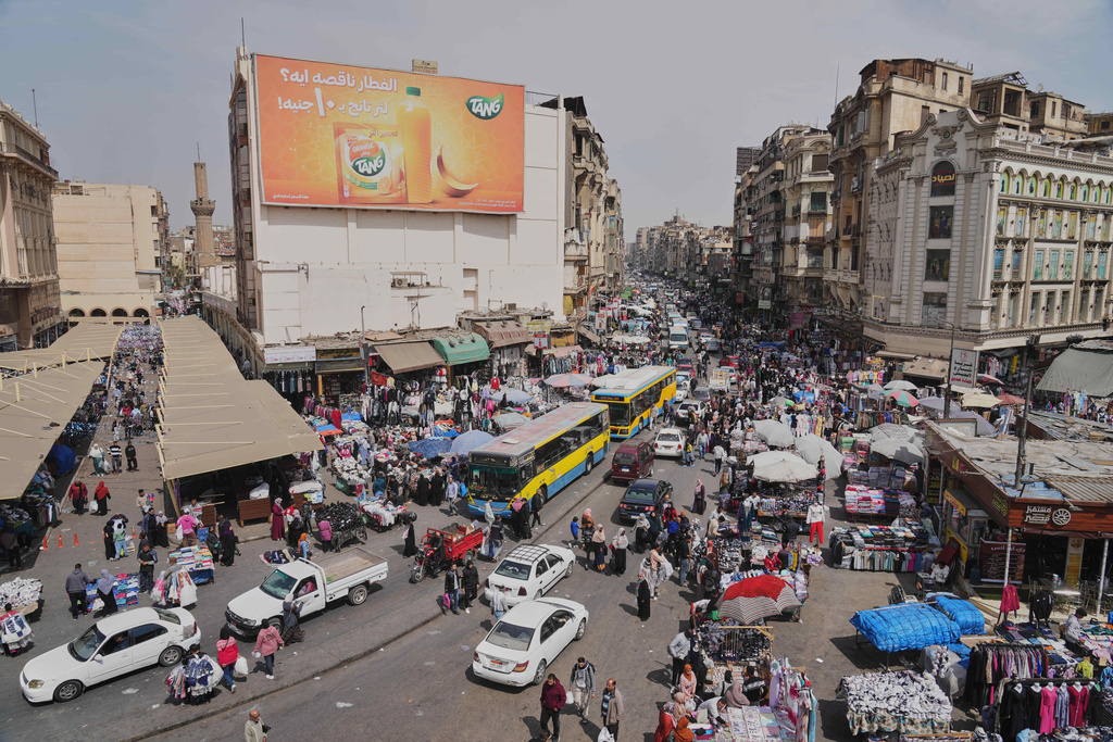 A view of people and vehicles at a popular market in Cairo, Egypt, Tuesday, March 12, 2026. (AP Photo/Amr Nabil)