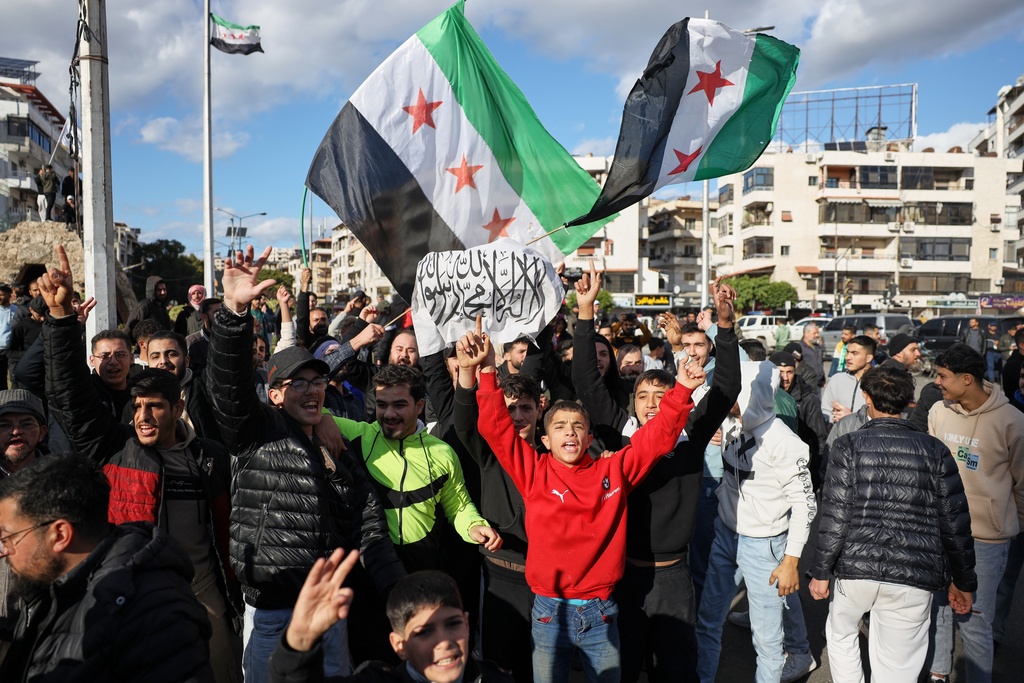Counter-protesters chant pro-government slogans at Alawite demonstrators, two days after a bomb in an Alawite mosque in Homs killed eight people and wounded 18 during Friday prayers, in Latakia, Syria's coastal region, Sunday, Dec. 28, 2025. (AP Photo/Omar Albam)