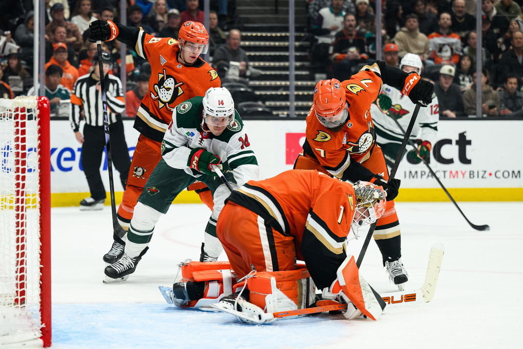 Minnesota Wild center Joel Eriksson Ek (14) tries to get the puck past Anaheim Ducks goaltender Lukas Dostal (1) and defenseman Radko Gudas (7) during the second period of an NHL hockey game Friday, Jan. 2, 2026, in Anaheim, Calif. (AP Photo/William Liang)