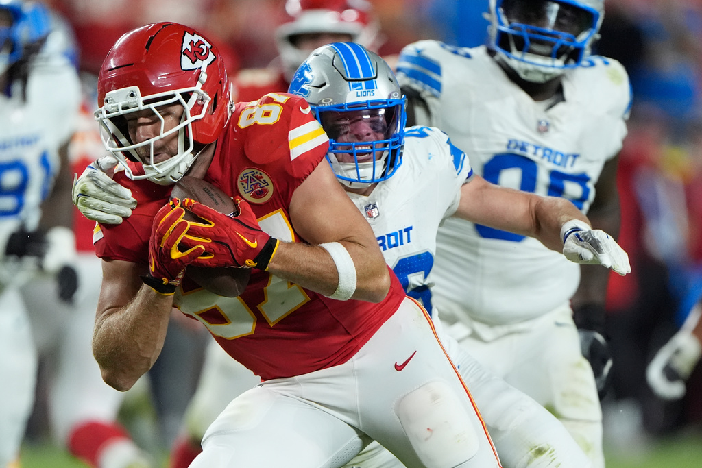 Kansas City Chiefs tight end Travis Kelce, left, gains a first down before being brought down by Detroit Lions linebacker Jack Campbell, right, during the second half of an NFL football game Sunday, Oct. 12, 2025, in Kansas City, Mo. (AP Photo/Charlie Riedel)1