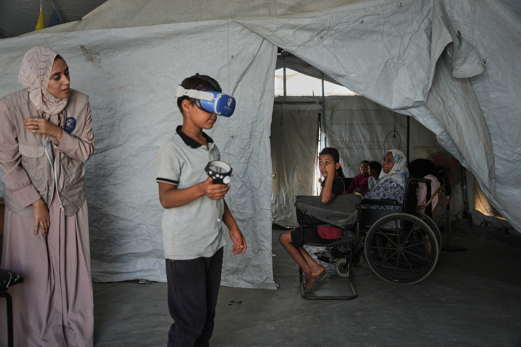 Ahmed Matar, 11, participates in a psychological support session using a virtual reality headset in a tent operated by a medical technology team in Zawaida, central Gaza Strip, Wednesday, June 17, 2026. (AP Photo/Abdel Kareem Hana)