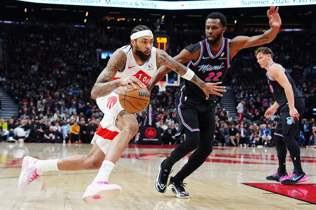 Toronto Raptors' Brandon Ingram (3) drives past Miami Heat's Andrew Wiggins (22) during the first half of an NBA basketball game in Toronto on Tuesday, April 7, 2026. (Frank Gunn/The Canadian Press via AP)