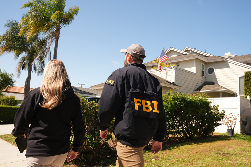FBI agents walk door to door to try to speak with neighbors, Sunday, April 26, 2026, near an address in Torrance, Calif., connected to Cole Tomas Allen, who was identified as the shooting suspect at the White House Correspondents Dinner the night before. (AP Photo/Damian Dovarganes)