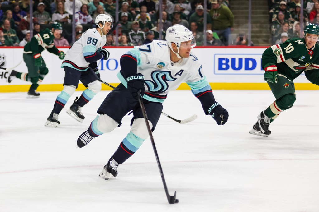 Seattle Kraken's Jaden Schwartz (17) controls the puck against the Minnesota Wild during the first period of an NHL hockey game Tuesday, April 7, 2026, in St. Paul, Minn. (AP Photo/Lily Dozier)