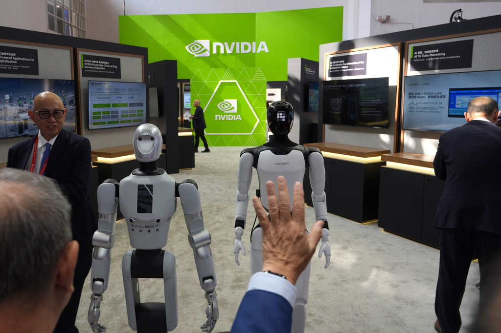 A visitor reacts near robots at the Nvidia booth during the China International Supply Chain Expo in Beijing on June 22, 2026. (AP Photo/Ng Han Guan)