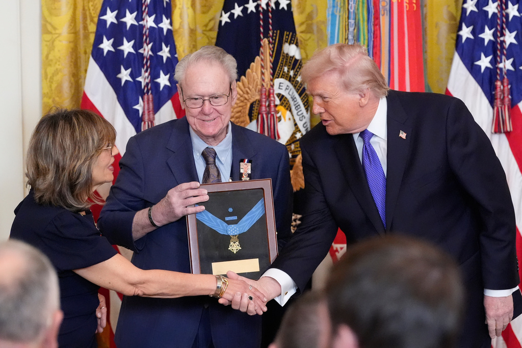 President Donald Trump posthumously presents the Medal Honor to Robert and Linda Ollis, parents of Staff Sergeant Michael Ollis, during a ceremony in the East Room of the White House, Monday, March 2, 2026, in Washington. (AP Photo/Alex Brandon)