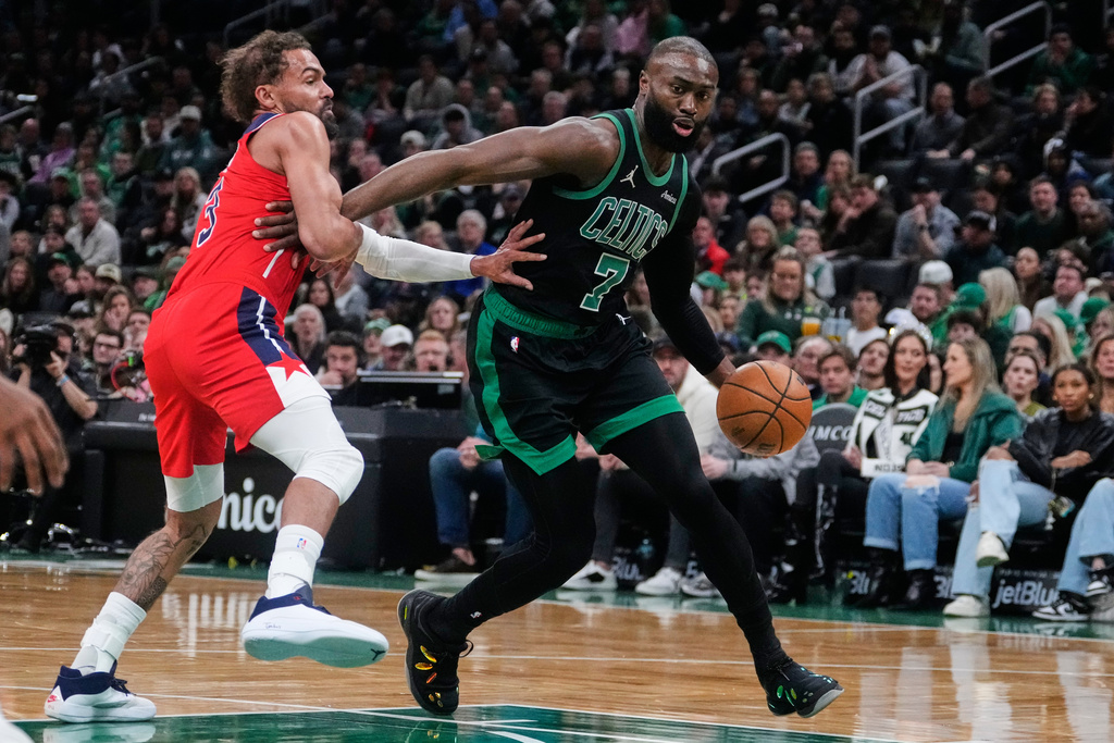 Boston Celtics guard Jaylen Brown (7) drives to the basket past Washington Wizards guard Trae Young, left, during the first half of an NBA basketball game, Saturday, March 14, 2026, in Boston. (AP Photo/Charles Krupa)