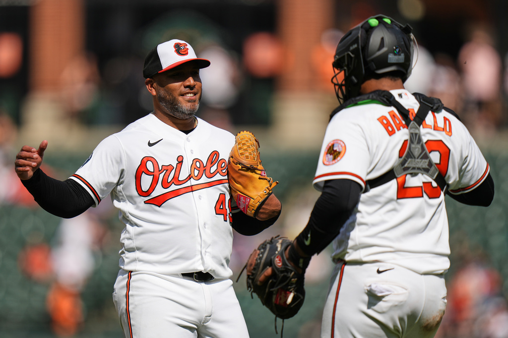Baltimore Orioles pitcher Albert Suarez, left, and catcher Samuel Basallo, right, celebrate their team's victory over the Texas Rangers after a pitch call was overturned through the Automated Ball-Strike system in the ninth inning of a baseball game, Wednesday, April 1, 2026, in Baltimore. (AP Photo/Stephanie Scarbrough)