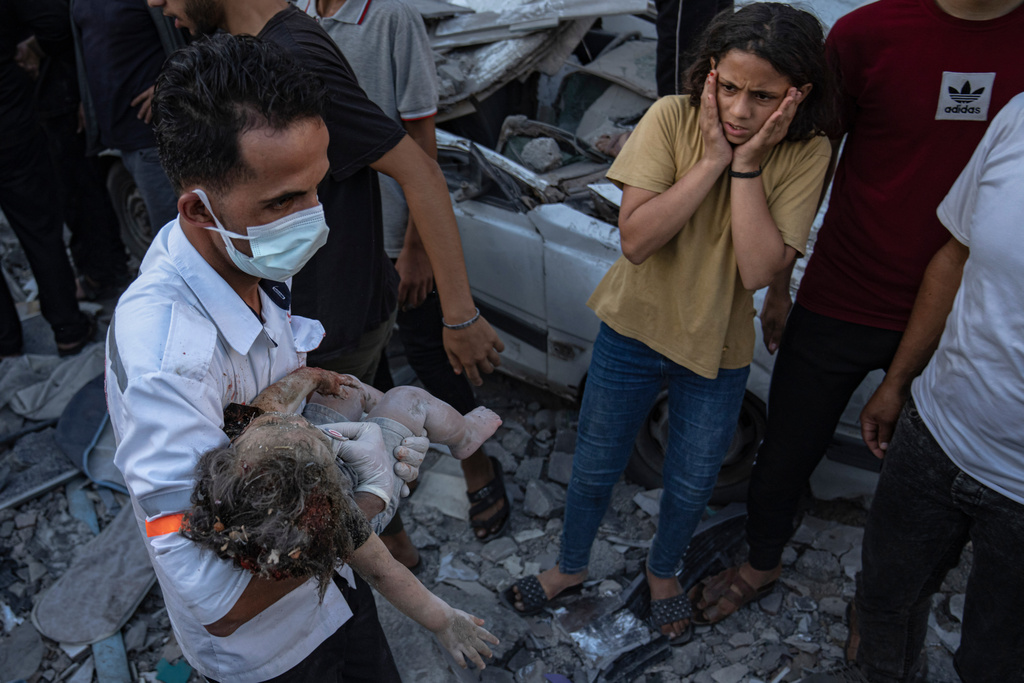 A girl reacts as a child is carried from the rubble of a building after an Israeli airstrike in Khan Younis, Gaza Strip, Saturday, Oct. 21, 2023. (AP Photo/Fatima Shbair)