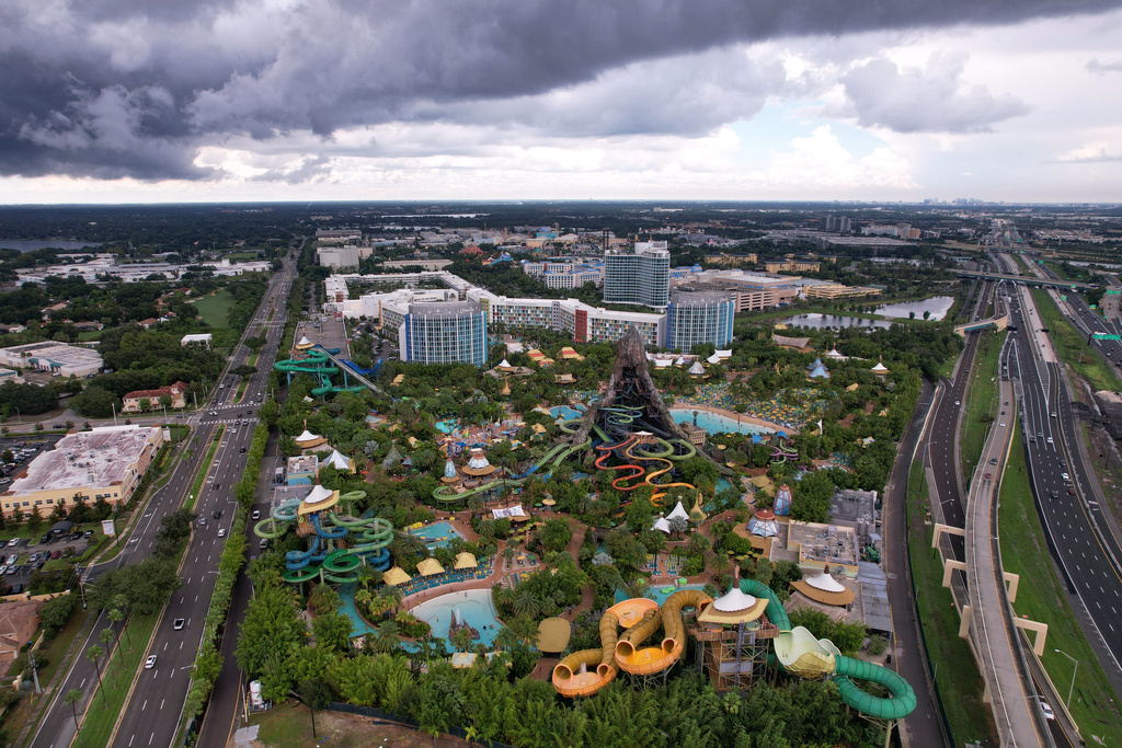 Hotels and highways are seen around Universal Volcano Bay water park, Friday, Aug. 22, 2025, in Orlando, Fla. Migrants who moved to central Florida in recent years say they were drawn by warm temperatures, a large migrant community, and the ease of finding jobs in one of the country's tourism and hospitality hotspots. (AP Photo/Rebecca Blackwell)