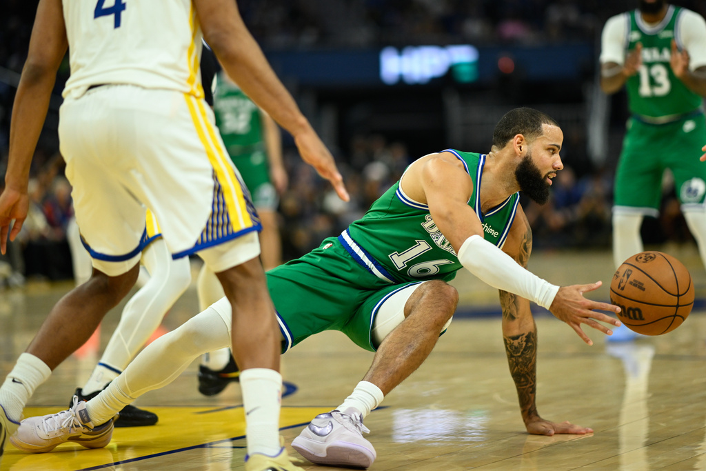 Dallas Mavericks forward Caleb Martin, right, attempts a pass against the Golden State Warriors during the first half of an NBA basketball game, Thursday, Dec. 25, 2025, in San Francisco. (AP Photo/Eakin Howard)