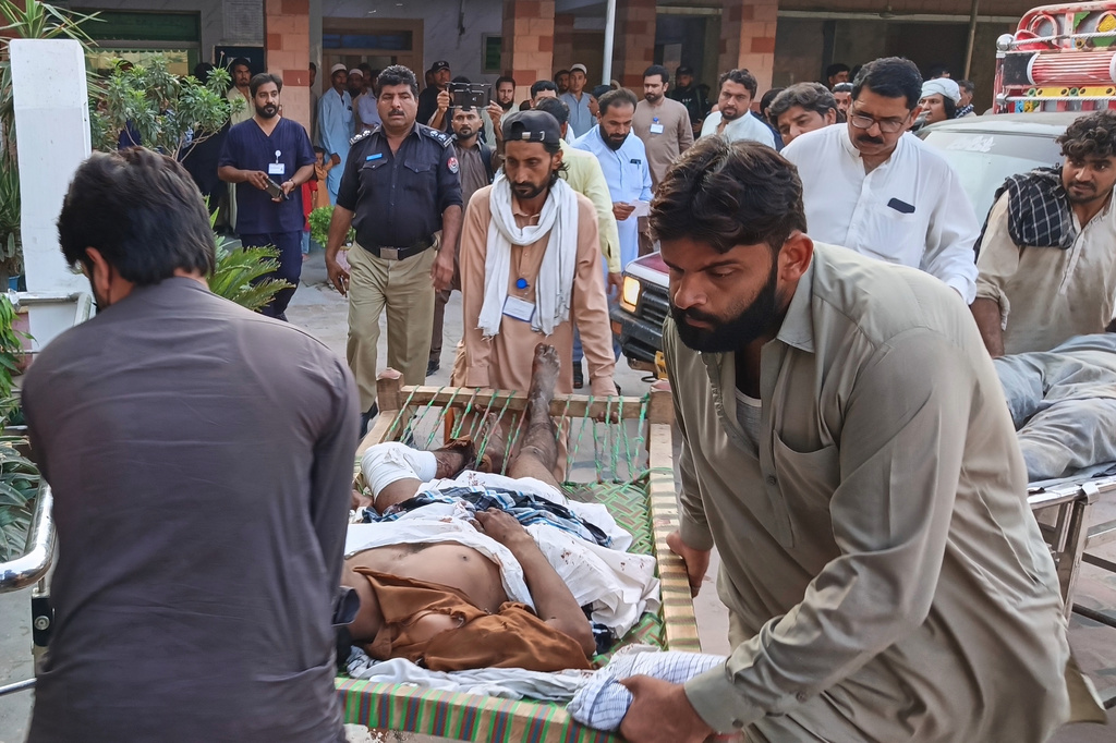 In this photo taken with a smartphone, volunteers transport an injured victim of a suicide attack on a roadside police checkpoint upon his arrival at a hospital in Dera Ismail Khan, Pakistan, Saturday, Sept. 26, 2026. (AP Photo/Kashif Naveed)