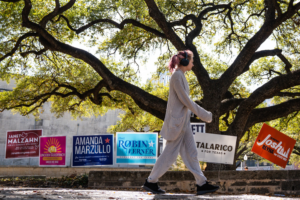 University of Texas students walk past election signs as campus becomes a polling place in the Texas primary election in the Union Building on campus, March 3, 2026. (Sara Diggins/Austin American-Statesman via AP)