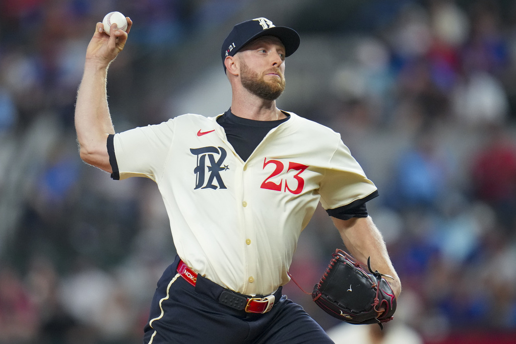 Texas Rangers pitcher Merrill Kelly throws a pitch to the Philadelphia Phillies during the first inning of a baseball game Friday, Aug. 8, 2025, in Arlington, Texas. (AP Photo/Julio Cortez)