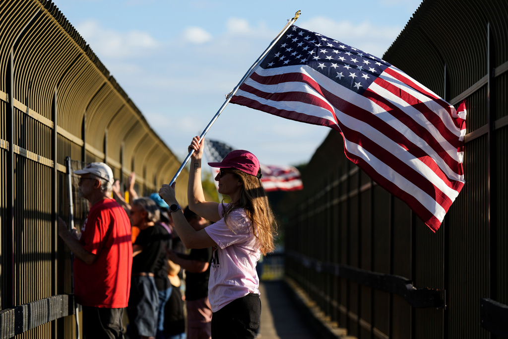 Jeannie Fanning waves an American flag while demonstrating above Interstate 40 in Nashville, Tenn., Friday, Sept. 26, 2025, against the deployment of the National Guard in Memphis. (AP Photo/George Walker IV)