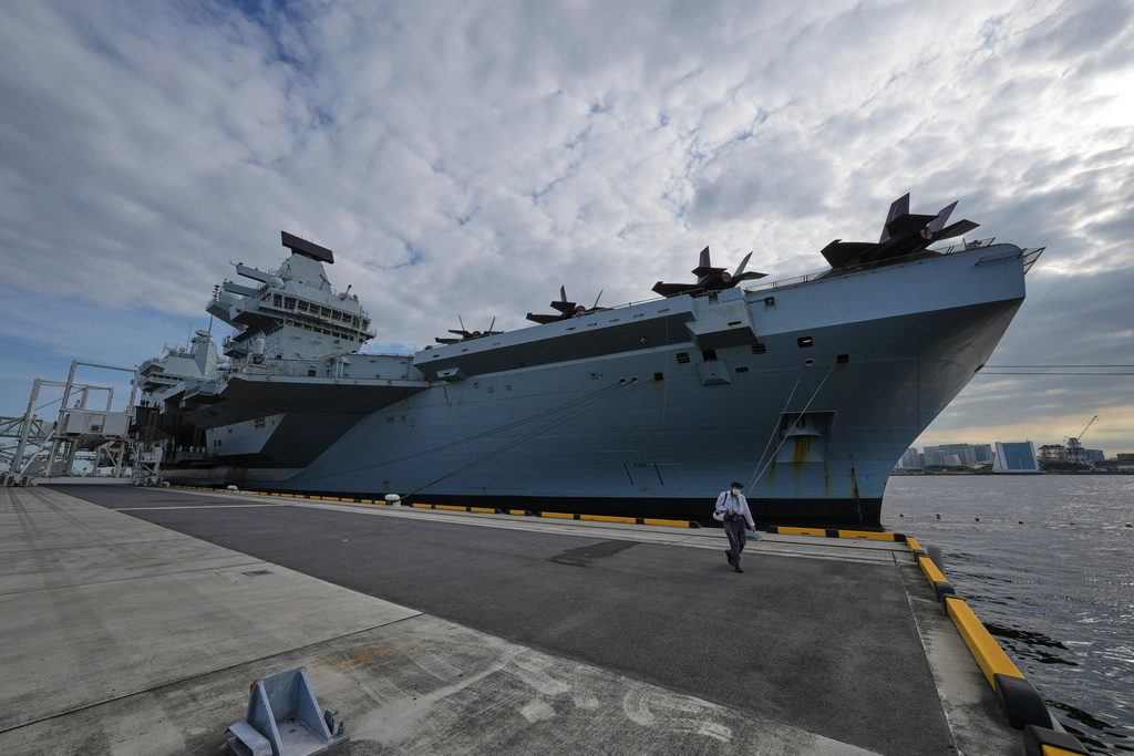 A journalist walks near the Royal Navy aircraft carrier HMS Prince of Wales before its port call in Tokyo Thursday, Aug. 28, 2025. (AP Photo/Eugene Hoshiko)