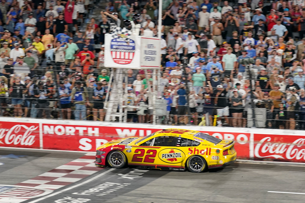 Joey Logano (22) takes th checkered flag to win a NASCAR Cup Series auto race in North Wilkesboro, N.C., Sunday, July 19, 2026. (AP Photo/Chuck Burton)