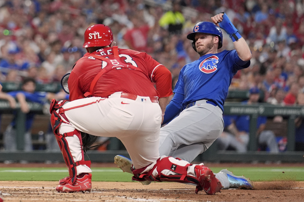 Chicago Cubs' Ian Happ, right, is tagged out at home by St. Louis Cardinals catcher Pedro Pages during the fourth inning of a baseball game Friday, Aug. 8, 2025, in St. Louis. (AP Photo/Jeff Roberson)