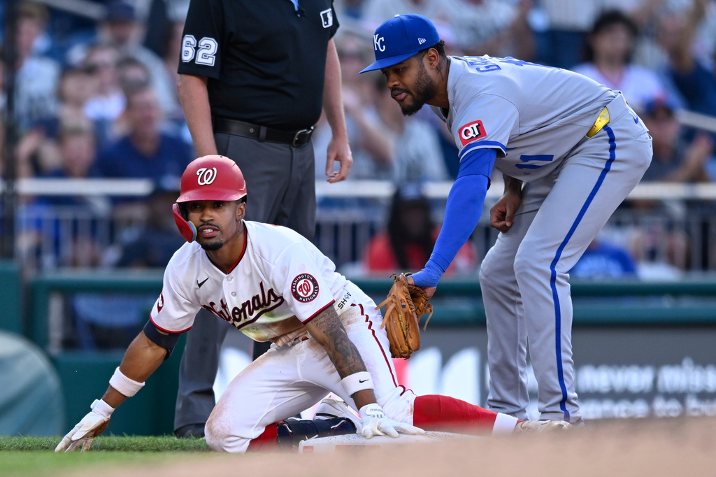 Washington Nationals's Nasim Nuñez beats the tag by Kansas City Royals third baseman Maikel Garcia for a RBI triple during the third inning of a baseball game, Tuesday, June 16, 2026, in Washington. (AP Photo/John McDonnell)