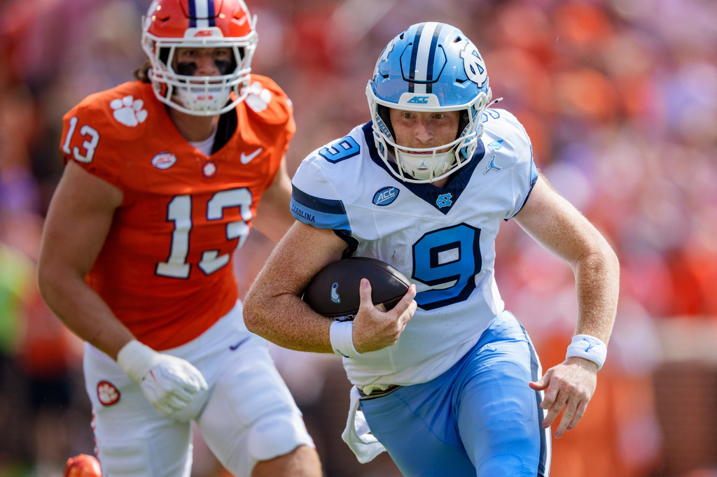 North Carolina quarterback Billy Edwards Jr. (9) runs with the ball while pursued by Clemson defensive end Will Heldt (13) in the first half of an NCAA college football game Saturday, Sept. 19, 2026, in Clemson, S.C. (AP Photo/Jacob Kupferman)