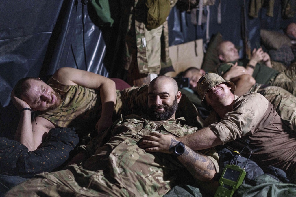 Ukrainian servicemen of the 148th artillery brigade rest in a dugout at the frontline in Zaporizhzhia region, Ukraine, on Thursday, Aug. 7, 2025. (AP Photo/Evgeniy Maloletka)
