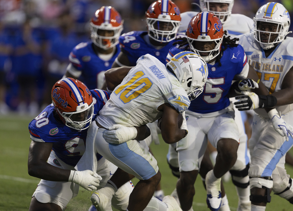 LIU Brooklyn running back Kam Ingram (10) gets stopped by Florida defensive lineman Brendan Bett (90) during the first half of an NCAA college football game Saturday, Aug. 30, 2025, in Gainesville, Fla. (AP Photo/Alan Youngblood)