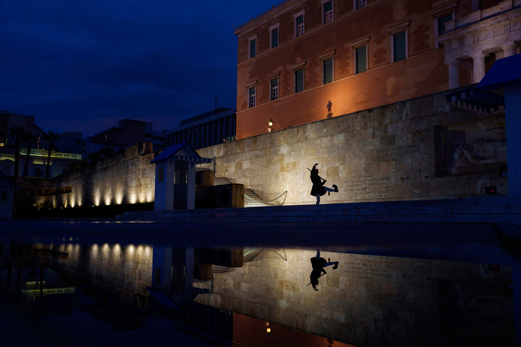 FILE - A presidential guard is reflected on a puddle following a downpour in Athens, in front of the Greek Parliament on March 1, 2024. (AP Photo/Petros Giannakouris, File)