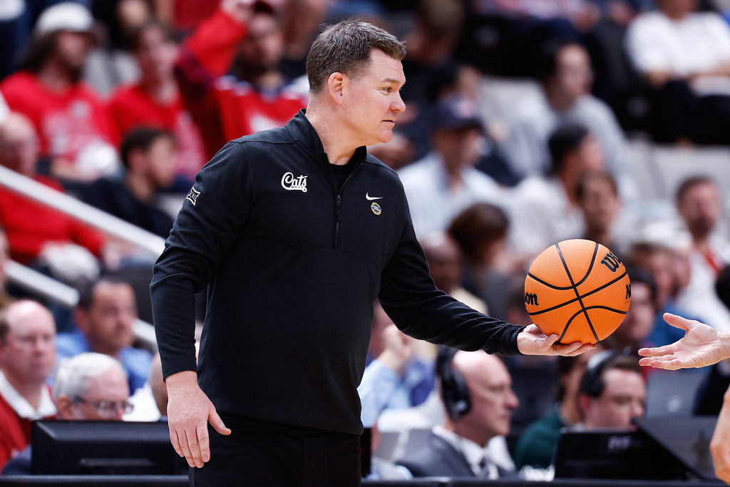 Arizona head coach Tommy Lloyd hands the ball to a referee during the second half in the Sweet 16 of the NCAA college basketball tournament against Arkansas, Thursday, March 26, 2026, in San Jose, Calif. (AP Photo/Kelley L Cox)