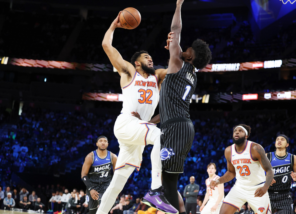 New York Knocks center Karl-Anthony Towns (32) and Orlando Magic forward Jonathan Isaac (1) tangle near the net during the first half of an NBA Cup semifinals basketball game, Saturday, Dec. 13, 2025, in Las Vegas. (AP Photo/Ronda Churchill)