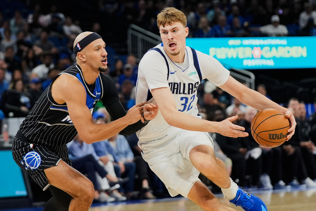 Dallas Mavericks forward Cooper Flagg (32) drives past Orlando Magic guard Jalen Suggs, left, during the first half of an NBA basketball game, Thursday, March 5, 2026, in Orlando, Fla. (AP Photo/John Raoux)
