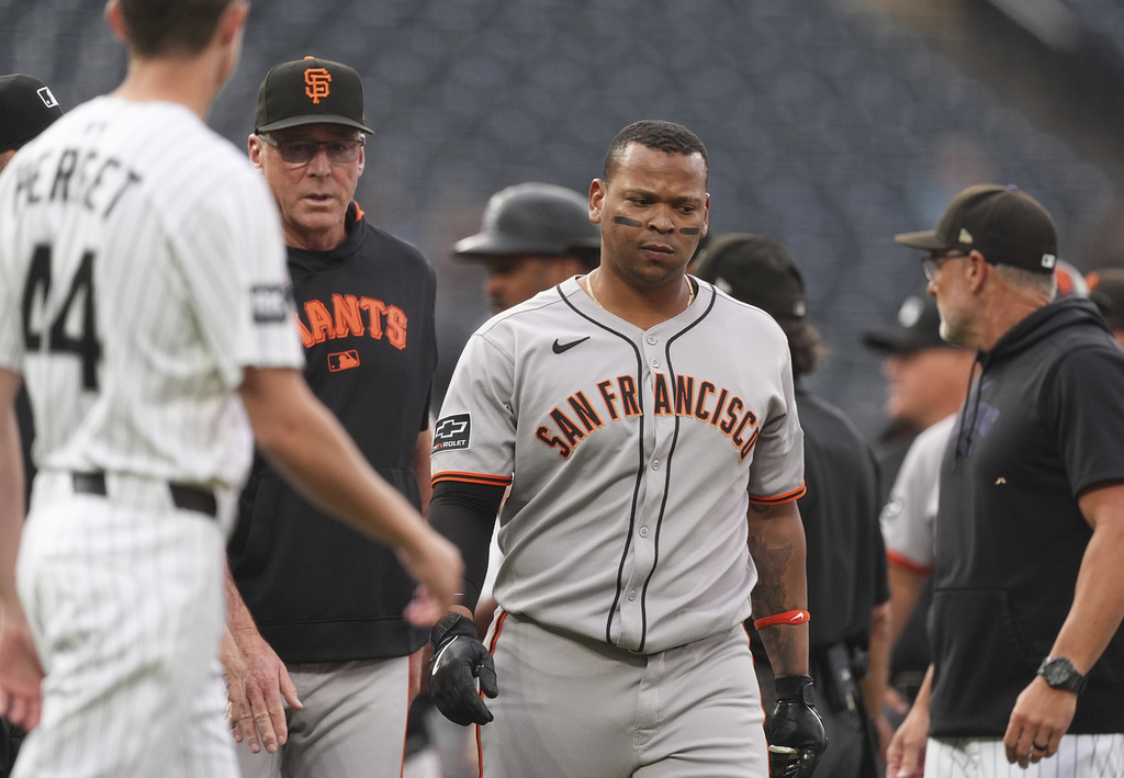San Francisco Giants manager Bob Melvin, center left, walks Rafael Devers away from a scuffle that started after Dever's two-run home run off Colorado Rockies starting pitcher Kyle Freeland in the first inning of a baseball game Tuesday, Sept. 2, 2025, in Denver. (AP Photo/David Zalubowski)