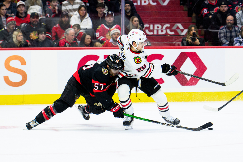 Ottawa Senators' David Perron (57) fights for control of the puck against Chicago Blackhawks' Ryan Greene (20) during second-period NHL hockey game action in Ottawa, Ontario, Saturday, Dec. 20, 2025. (Spencer Colby/The Canadian Press via AP)