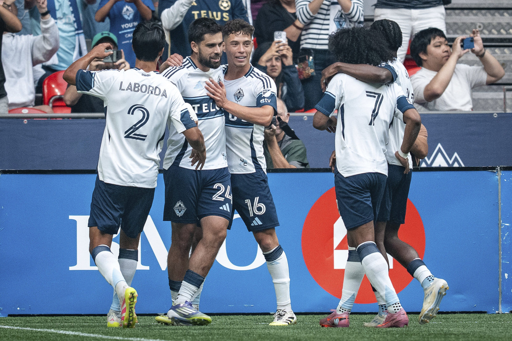Vancouver Whitecaps' Brian White celebrates his goal against the Houston Dynamo with Mathias Laborda (2), Sebastian Berhalter and Jayden Nelson (7) during the first half of an MLS soccer match in Vancouver, British Columbia, Sunday, Aug. 17, 2025. (Ethan Cairns/The Canadian Press via AP)