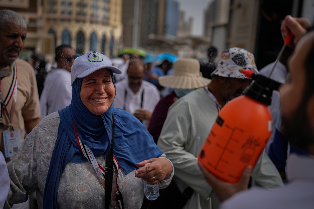 A Muslim pilgrim reacts as a volunteer sprays water to cool them outside the Grand Mosque during the annual hajj pilgrimage at the holy city of Mecca, Saudi Arabia, Sunday, May 24, 2026. (AP Photo/Altaf Qadri)