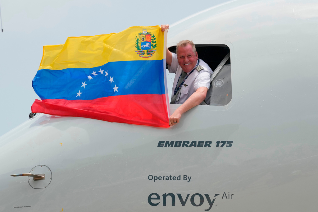 FILE - The pilot of a U.S. aircraft holds a Venezuelan flag from the cockpit window after landing at Simon Bolivar International Airport in Maiquetia, Venezuela, Thursday, April 30, 2026, as direct air service between the United States and Venezuela resumes after seven years. (AP Photo/Ariana Cubillos, File)
