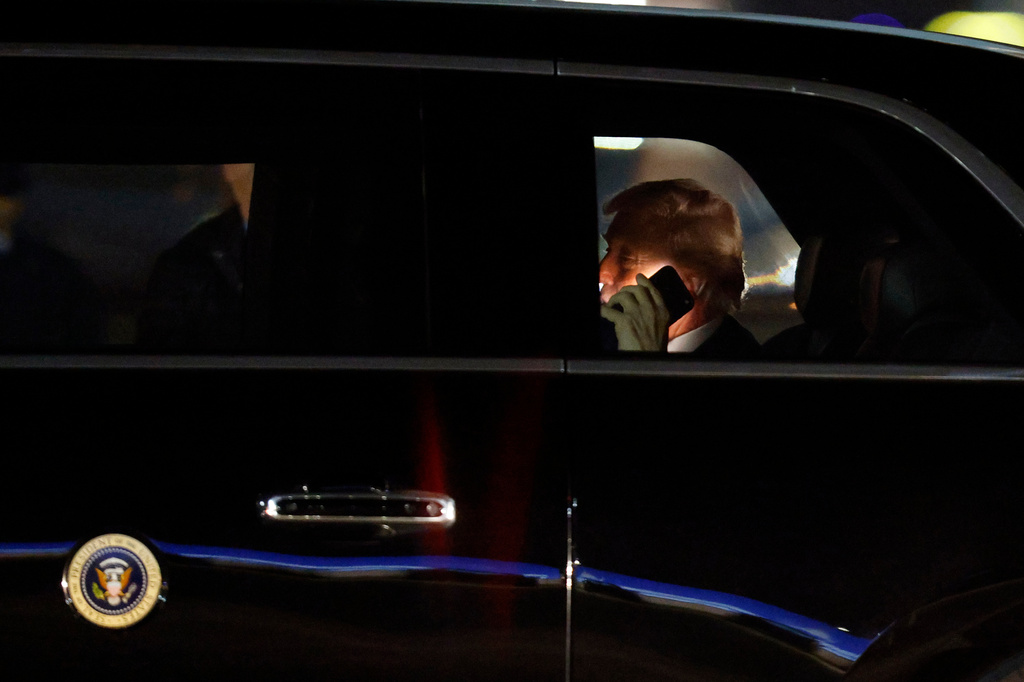 FILE - President Donald Trump talks on his cell phone in his limousine, known as "The Beast," upon his arrival at Joint Base Andrews, Md., March 6, 2026. (AP Photo/Luis M. Alvarez, File)