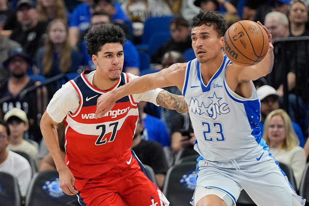 Orlando Magic forward Tristan da Silva (23) grabs a loose ball in front of Washington Wizards guard Will Riley (27) during the first half of an NBA basketball game, Thursday, March 12, 2026, in Orlando, Fla. (AP Photo/John Raoux)