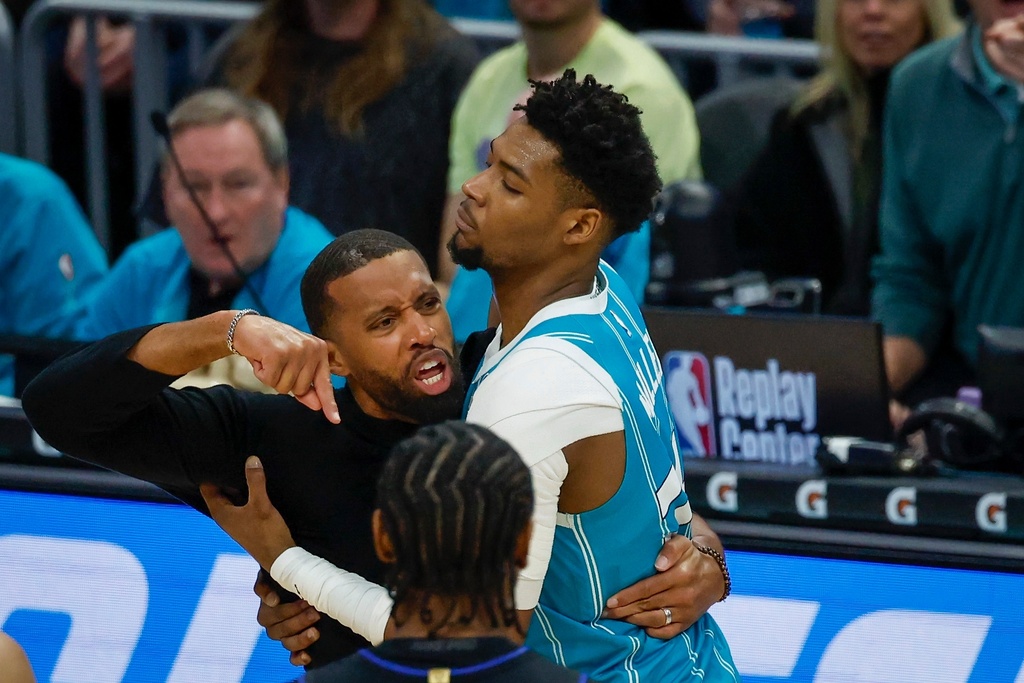 Charlotte Hornets forward Brandon Miller, right, holds back Hornets head coach Charles Lee, left, who yells at an official during the second half of an NBA basketball game against the Detroit Pistons in Charlotte, N.C., Monday, Feb. 9, 2026. Lee was ejected from the game. (AP Photo/Nell Redmond)