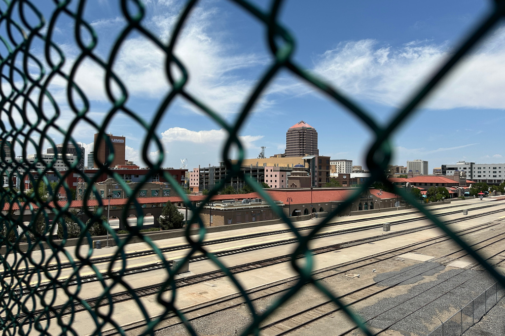 The tallest building in downtown Albuquerque, N.M., which houses the U.S. attorney's office, is seen beyond a chain link fence on Friday, June 12, 2026. (AP Photo/Susan Montoya Bryan)