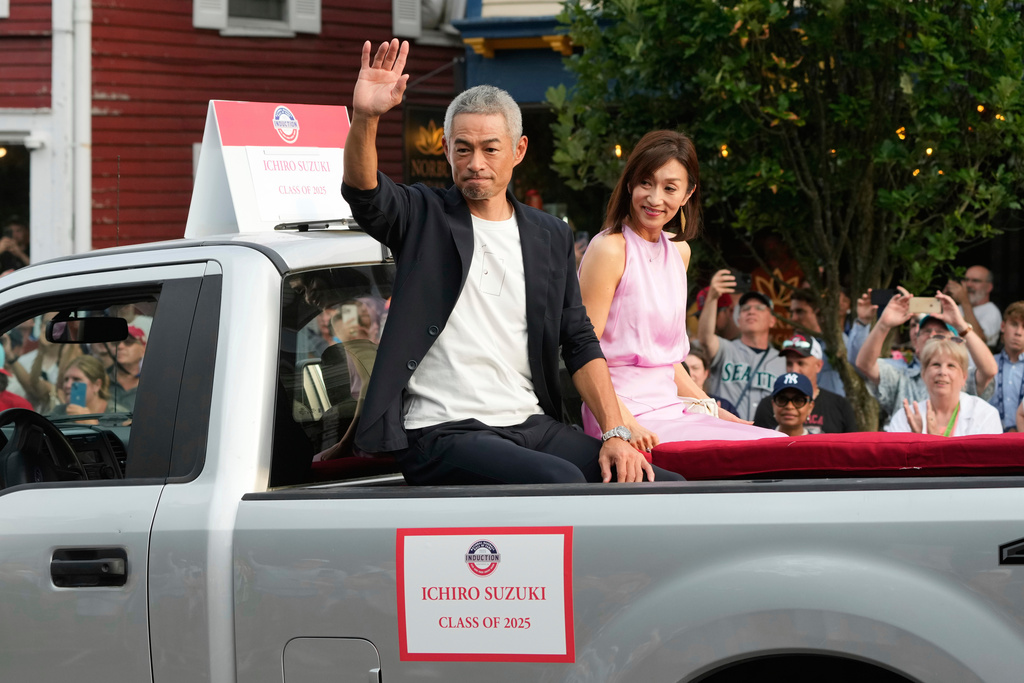 FILE - Baseball Hall of Fame inductee Ichiro Suzuki, left, and his wife Yumiko Suzuki reacts during the Baseball Hall of Fame Parade of Legends in Cooperstown, N.Y., July 26, 2025. (AP Photo/Seth Wenig, File)