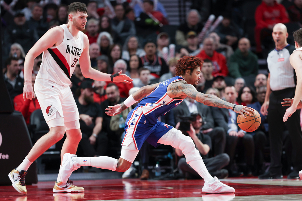 Philadelphia 76ers forward/guard Kelly Oubre Jr. (9) grabs for a loose ball ahead of Portland Trail Blazers center Donovan Clingan (23) during the second half of an NBA basketball game Monday, Feb. 9, 2026, in Portland, Ore. (AP Photo/Amanda Loman)