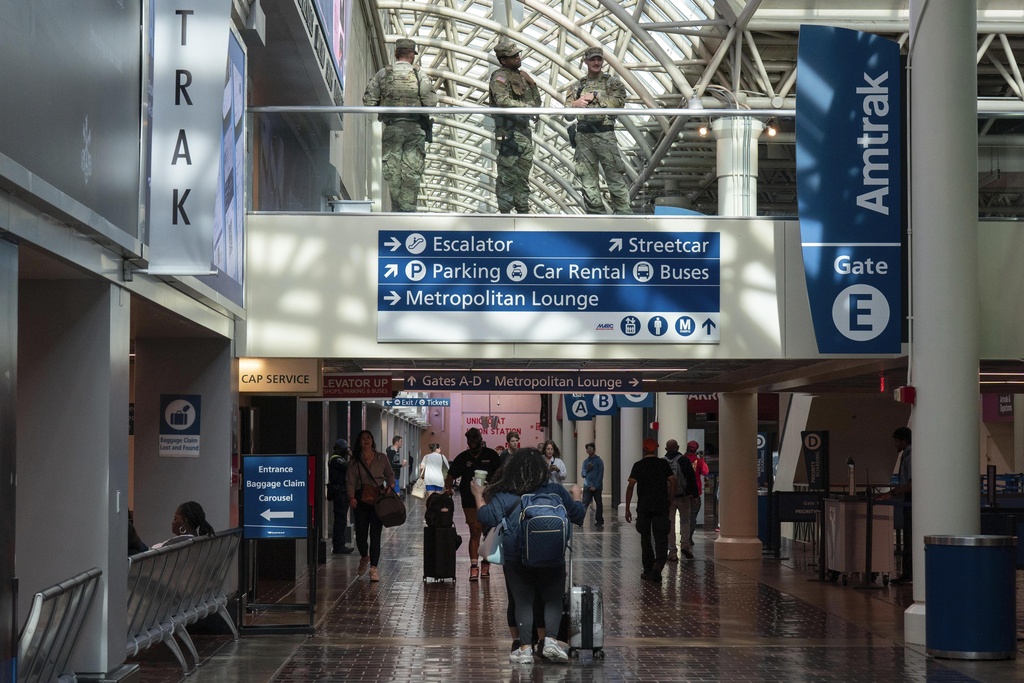Members of the Louisiana National Guard, top, patrol the passengers area in Union Station, Saturday, Aug. 30, 2025, in Washington. (AP Photo/Jose Luis Magana)