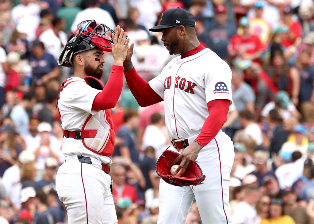 Boston Red Sox catcher Connor Wong, left, and pitcher Aroldis Chapman, right, high-five after a baseball game against the Cleveland Guardians, Monday, Sept. 1, 2025, in Boston. (AP Photo/Mark Stockwell)
