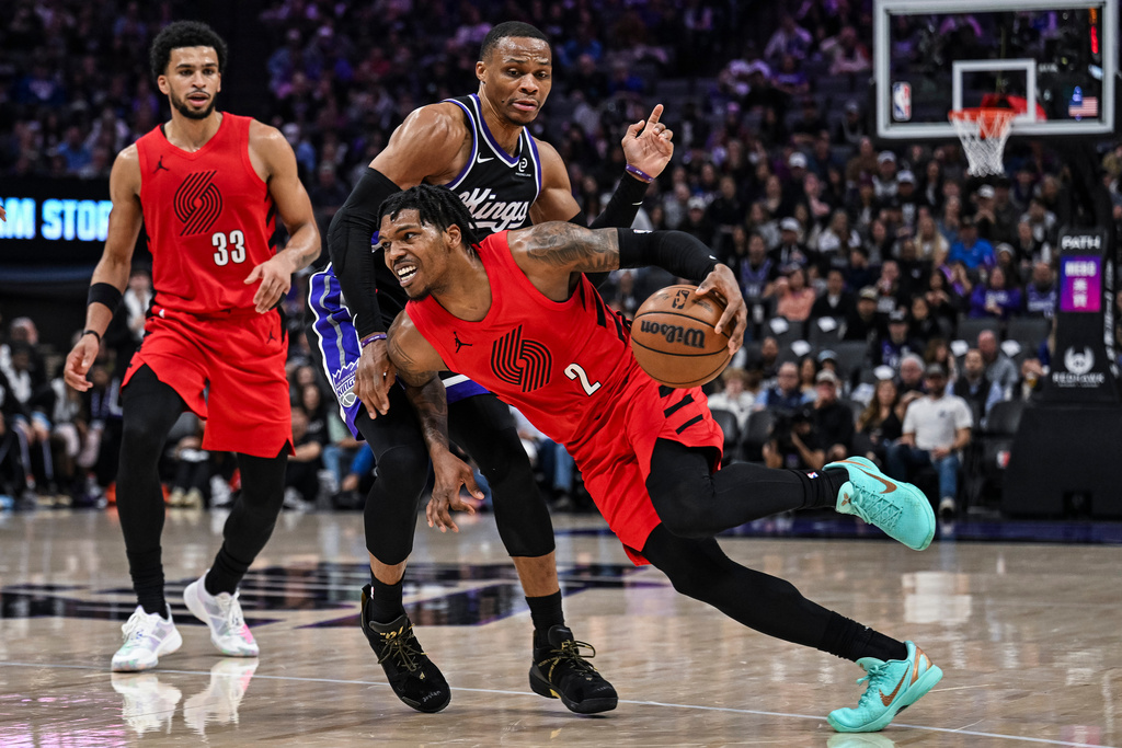 Portland Trail Blazers guard Caleb Love (2) dribbles past Sacramento Kings guard Russell Westbrook, back, during the first half of an NBA basketball game, Sunday, Jan. 18, 2026, in Sacramento, Calif. (AP Photo/Justine Willard)