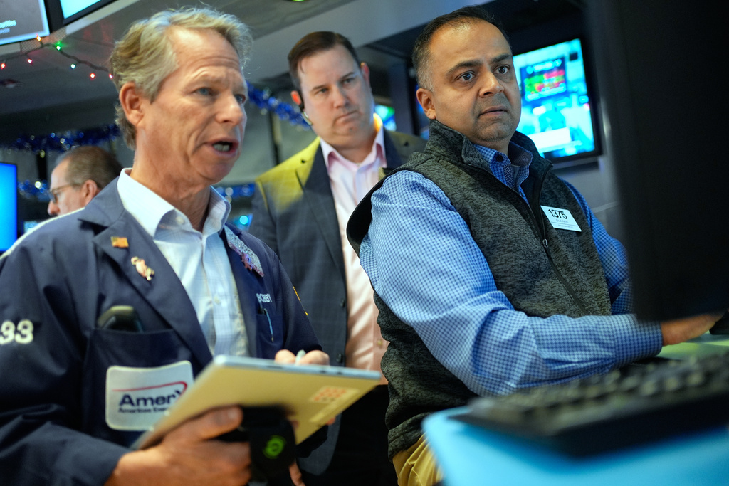 Dilip Patel, right, and Bobby Charmak, left, work on the floor at the New York Stock Exchange in New York, Wednesday, Dec. 10, 2025. (AP Photo/Seth Wenig)