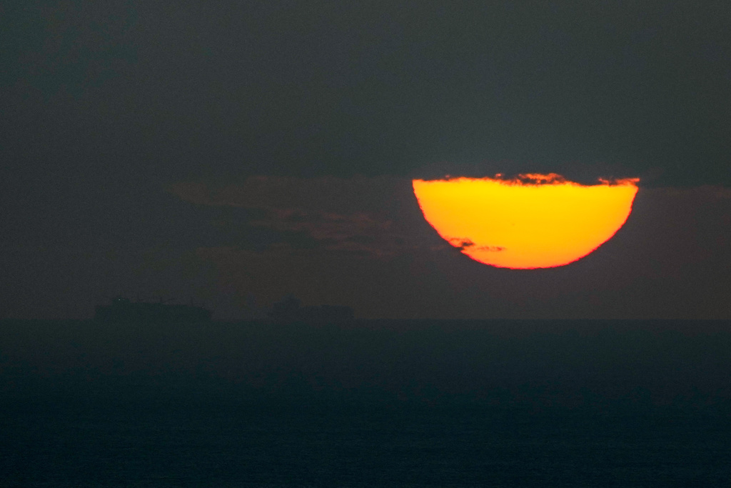 Ships sail through the Arabian Gulf toward the Strait of Hormuz as the sun sets in the United Arab Emirates Monday, March 23, 2026. (AP Photo)