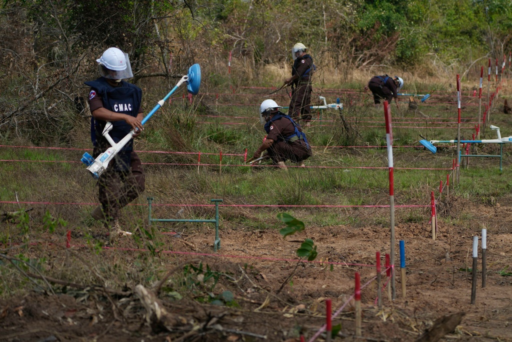 FILE - Cambodia Mine Action Center, CMAC, staff members work to demine a minefield in Preytotoeung village, Battambang province, Cambodia, Thursday, Jan. 19, 2023. (AP Photo/Heng Sinith, File)
