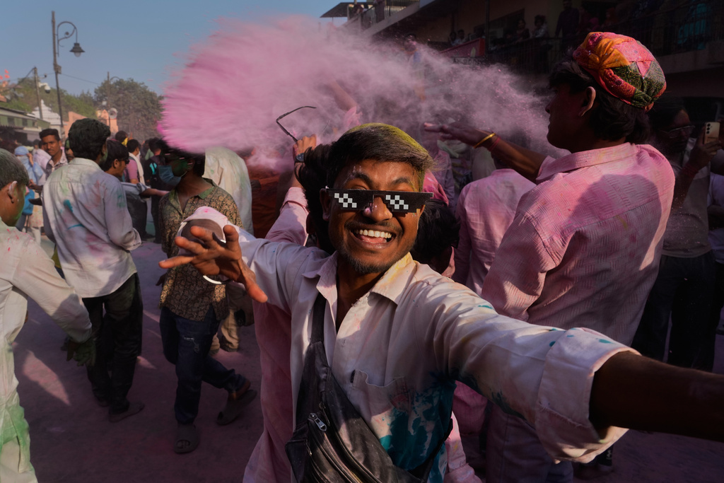 Revelers dance in a street during a procession celebrating the Holi festival in Mathura, India, on Feb. 27, 2026. (AP Photo/Manish Swarup)